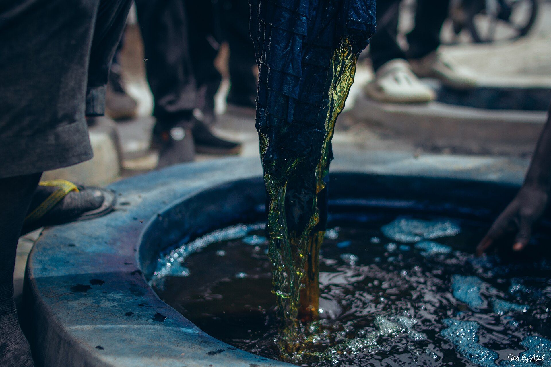 Indigo-dyed cloth being lifted from a dye pit at Kofar Mata, Kano